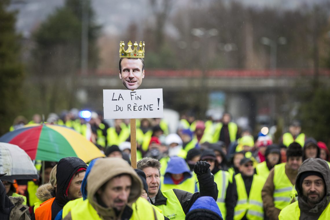 A placard reads “The end of the reign” with the face of President Macron on top as demonstrators take part in yellow vest demonstration in Annecy, France, in 2018.